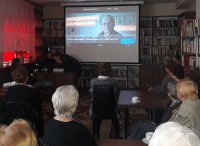 kolorowe zdjęcie, osoby starsze oglądają film wyświetlany na ekranie przez projektor