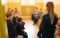 policjantka rozmawia uczniami w pomieszczeniu dla osób zatrzymanych