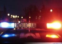 zdjęcie kolorowe, widoczny jest na nim policyjny radiowóz, który na dachu ma włączone światła błyskowe