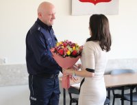 Na zdjęciu widać Zastępcę Komendanta Powiatowego Policji w Sokółce kom. Janusza Sepko który otrzymuje kwiatu od kobiety