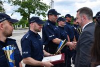 Na zdjęciu widać policjantów w szeregu odbierających gratulacje, wśród nich jest Grzegorz Poczobutt Odlanicki