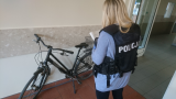 Policjantka wykonuje czynności procesowe z zabezpieczonym skradzionym rowerem.
