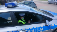 Policjantka ruchu drogowego w radiowozie w trakcie czynności służbowych.