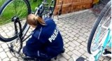 Policjantka w trakcie sprawdzania numeru ramy przed oznakowaniem roweru.