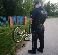 Policjant w trakcie sprawdzania numeru ramy roweru.
