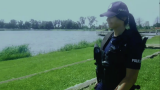 Policjantka w trakcie patrolu w rejonie zbiornika wodnego.