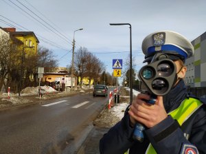 policjantka mierzy prędkość pojazdów w tle przejście dla pieszych