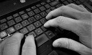 dłonie wciskające klawisze klawiatury komputerowej