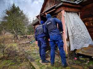 Policjanci sprawdzają dom gdzie mogą przebywać osoby bezdomne.