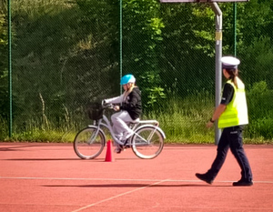 Policjantka i dziecko na rowerze.