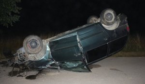 Osobowy ford leży na dachu po tym jak pijany kierowca stracił panowanie nad pojazdem i uderzył w przydrożne drzewo.