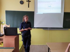 Policjantka prowadzi spotkanie profilaktyczne dla uczniów z Dąbrowy Białostockiej na temat cyberzagrożeń.