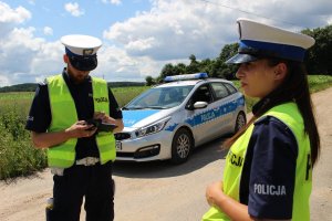 Policjanci Wydziału Ruchu Drogowego wypełniają dokumentacje związana z kontrola drogową.