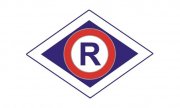 Policyjne logo wydziału ruchu drogowego, na środku wielka litera R, otoczona czerwony okręgiem, na granatowym tle.