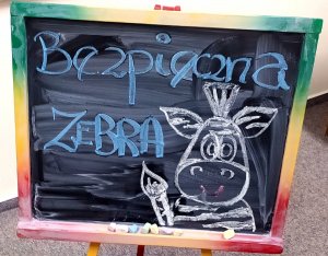 Tablica z rysunkiem zebry i napisem &quot;Bezpieczna Zebra&quot;