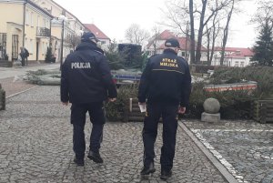 Policjant wraz z funkcjonariuszem Straży Miejskiej podczas patrolu w rejonie punktu sprzedaży świątecznych drzewek w centrum miasta Sokółka.