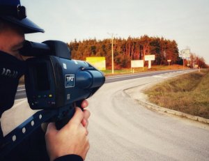 Policjant kontroluje prędkość jadących samochodów.