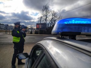 radiowóz w tle policjantka z ręcznym miernikiem prędkości