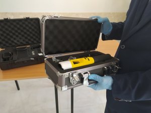 alkomat iblow w walizce trzymanej przez mężczyznę w niebieskiej rękawiczkach