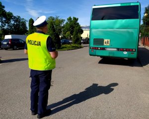 policjant przed nim zielony autobus