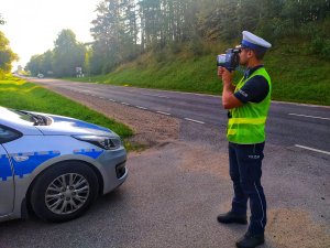 policjant mierzy prędkość w tle droga