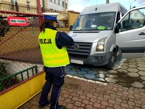 policjantka sprawdza oświetlenie samochodu