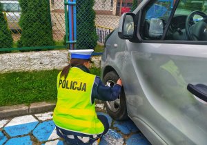 policjantka sprawdza stan opon samochodu