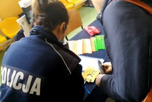 policjanta pokazuje ulotki o dopalaczach innej kobiecie