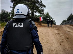 policjanci strzegą granicy w tle flaga Polski