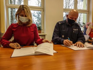 kobieta i policjant podpisują dokumenty