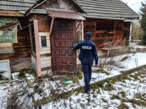 policjantka wchodzi do drewnianego domu