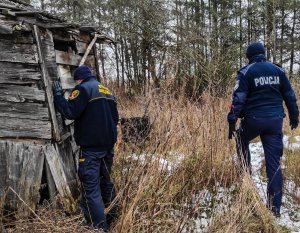 policjantka i strażnik miejski sprawdzają pustostan