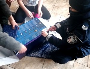 mężczyzna i policjantka rozpakowują prezent