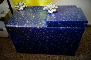 dwa świąteczne prezenty mniejsze opakowanie leżące na większej paczce