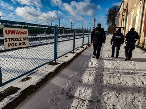 policjantka i funkcjonariusze straży ochrony kolei sprawdzają rejon dworca PKP