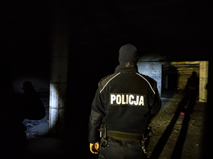 policjant sprawdza pustostan oświetla pomieszczenie latarką