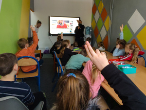 w sali policjantka przed nią grupa dzieci