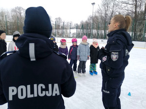 Rozpoczęcie konkursu na lodowisku przez policjantki dla uczestników półkolonii.