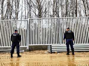 Policjanci zabezpieczający budowę zapory na granicy.