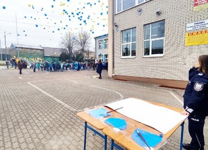 Policjantka w trakcje obchodów Światowego Dnia Autyzmu. Puszczenie balonów do nieba.