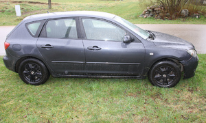 Ciemny samochód zaparkowany bokiem.