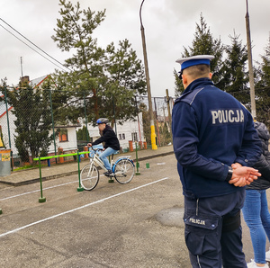 Policjanci nadzorujący dzieci jeżdżące na rowerach podczas zawodów.