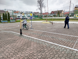 Policjanci nadzorujący dzieci jeżdżące na rowerach podczas zawodów.