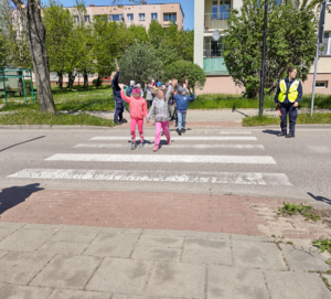 Policjantki z dziećmi przechodzące przez przejście dla pieszych.