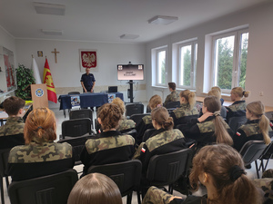 Uczniowie i policjanci na sali.