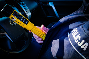 Urządzenie do sprawdzania stanu trzeźwości trzymane przez policjanta.