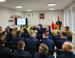 Policjanci omawiają prezentację multimedialną.