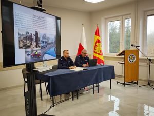 Policjanci omawiają prezentację multimedialną.