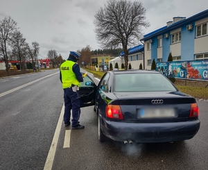 Policjant  bada trzeźwość kierowcy.