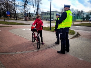 Policjanci rozmawiają z rowerzystką.